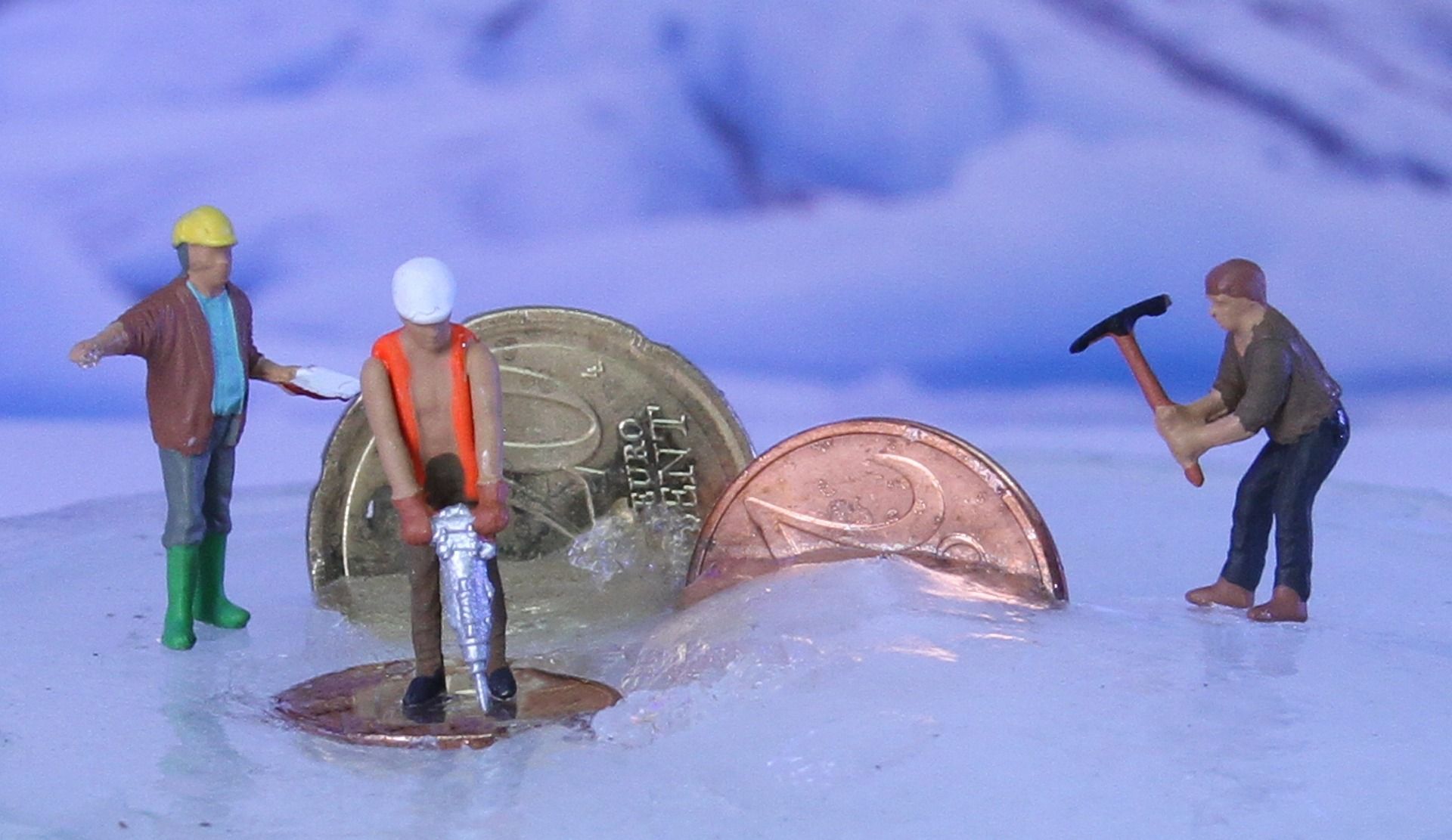 Foto von Bauarbeiterfiguren auf Geldmünzen stehend