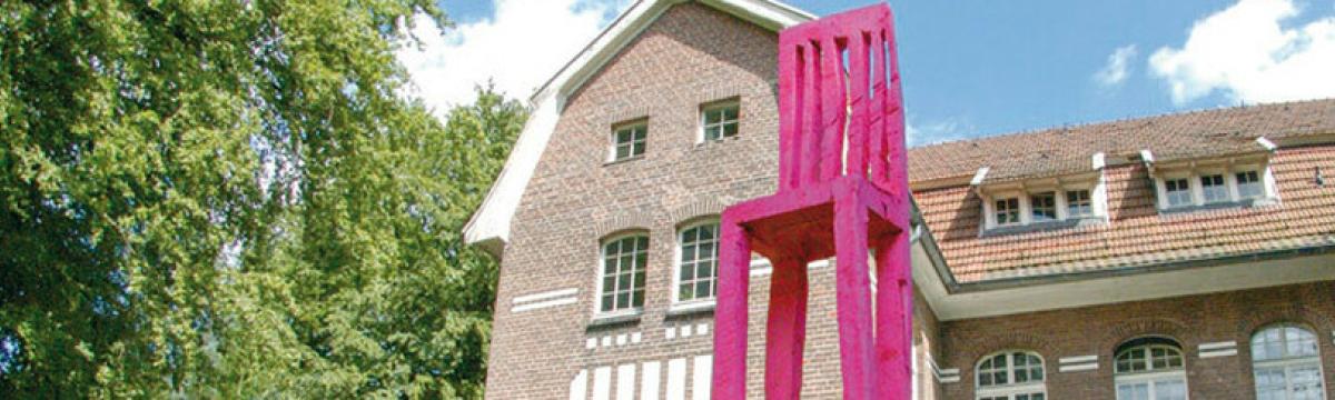 ArToll Foto von einem übergroßen pinken Stuhl vor dem Gebäude des ArToll