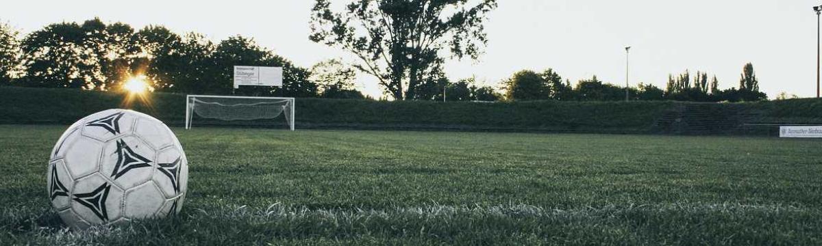Foto eines Fußballs mit Tor auf einem Fußballplatz