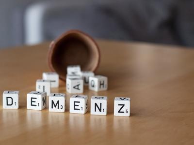 Foto eines Knobelbechers mit Würfeln mit der Aufschrift Demenz