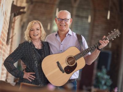 Foto von Frau und Mann mit Gitarre